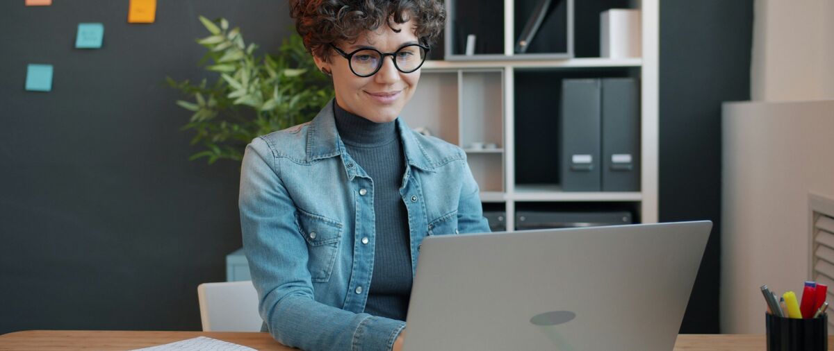 Mitarbeiterin am Laptop an ihrem Arbeitsplatz im Sekretariat